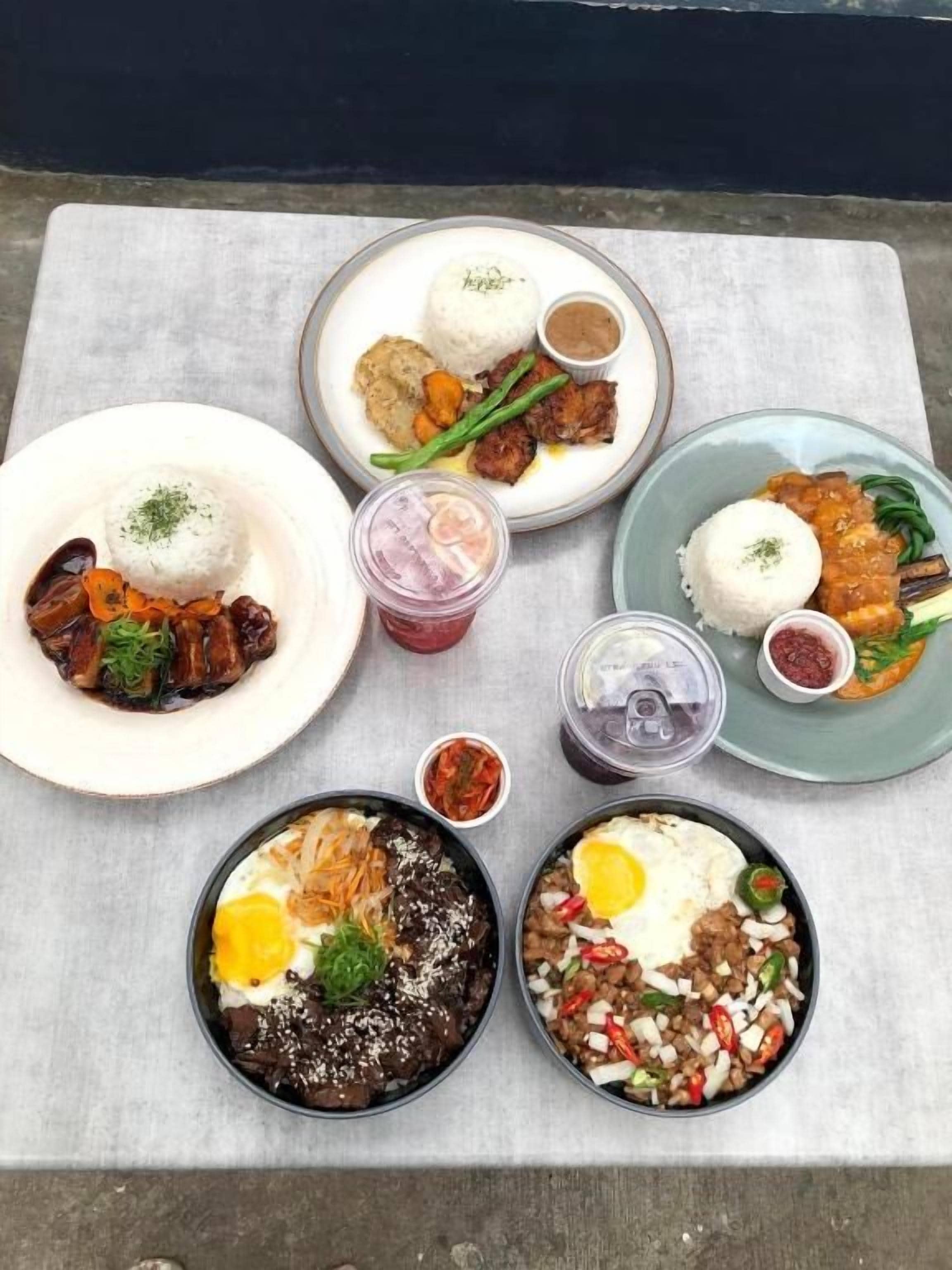 Uma mesa com diversos pratos, incluindo arroz, carne e legumes, sugerindo uma refeição.