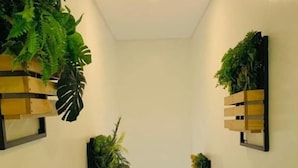 A staircase with a metal railing, flanked by wall-mounted planters with greenery. - Kojo Hotel (Tagum)