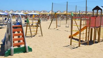 Kids can play on the beachside playground with a ladder, swings, and slide.