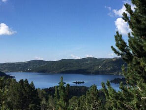 A lake surrounded by forested hills. - Welcome to Soleil, à la Neige, a pleasant family resort where life is good! (Eyne)