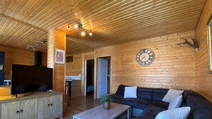 A wooden interior with a sofa, TV, and a clock on the wall. - Welcome to Soleil, à la Neige, a pleasant family resort where life is good! (Eyne)