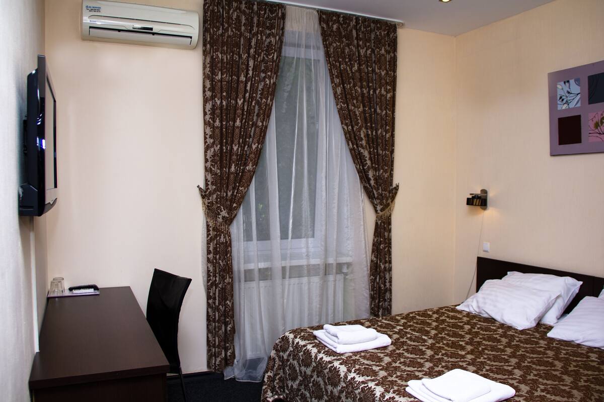 Una habitación de hotel con cama, escritorio y silla.