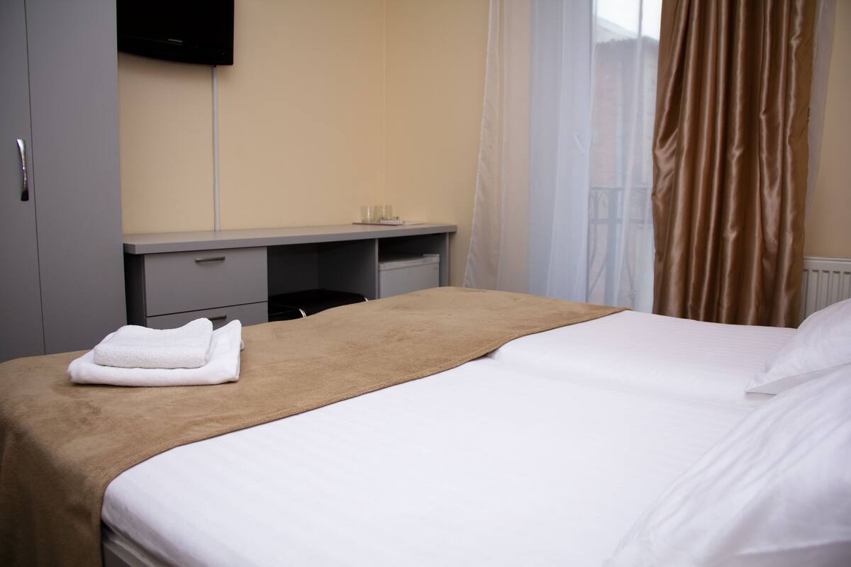 Una habitación de hotel con una cama, un escritorio y un televisor.