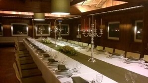 A long dining table set with white tablecloths, plates, glasses, and a centerpiece. - Hotel Rural Quinta da Vista Alegre (Pacos De Ferreira)
