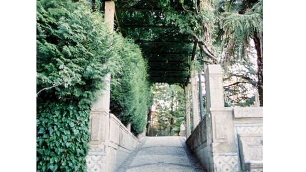 A stone pathway flanked by lush greenery and a pergola overhead. - Hotel Rural Quinta da Vista Alegre (Pacos De Ferreira)