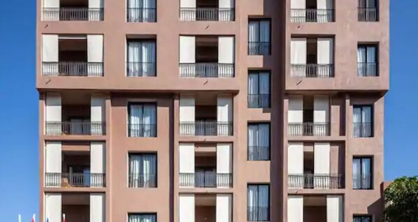 A multi-story building with balconies and windows.