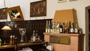 A bar area with a wooden counter, a wine glass, and a cabinet with bottles. - Brauerei-Gasthof-Hotel Laupheimer (Westerheim)