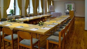 A conference room with a long table, chairs, and a projector screen. - Brauerei-Gasthof-Hotel Laupheimer (Westerheim)