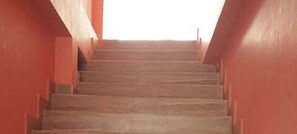 Eine Treppe mit brauner Handläufe und Stufen, die nach oben führen, umgeben von roten Wänden.