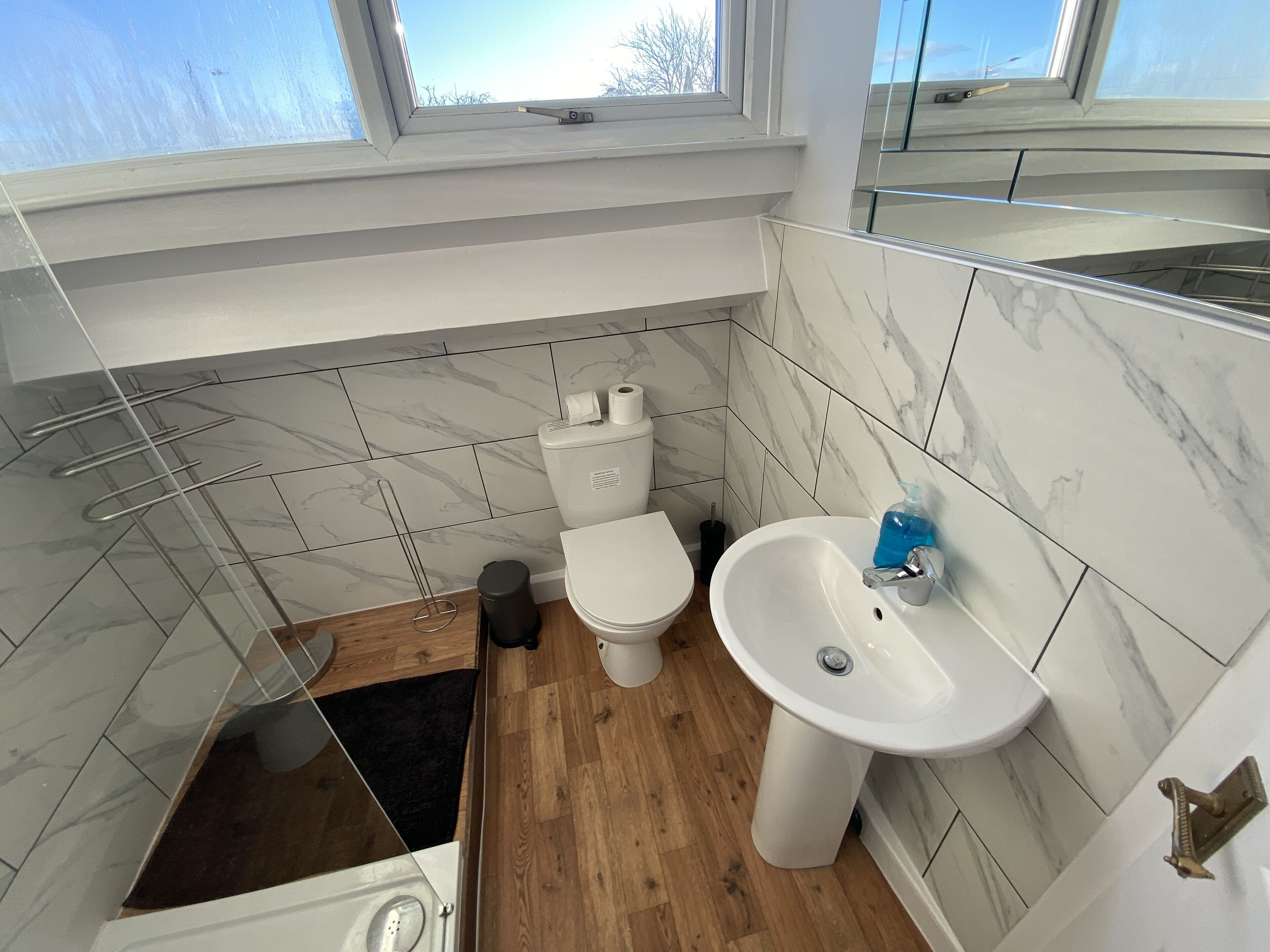A bathroom with a toilet, sink, and shower.