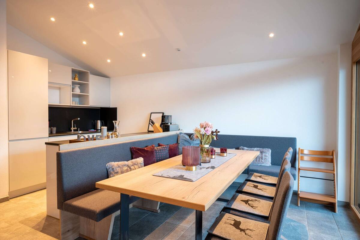 Un espace de vie moderne comprenant un coin repas, une cuisine et un coin salon.