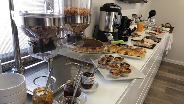 A buffet with various food items including pastries, a coffee machine, and condiments. - Casa Jerónimo B&B (Lamego)