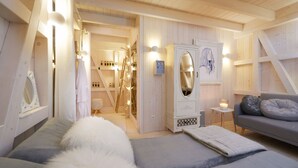 Une chambre à coucher comprenant un lit, une commode, une coiffeuse avec un miroir et une table de chevet avec une lampe.