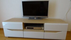 A flat-screen TV on a white entertainment unit with a wooden top. - Apartment Bad Rappenau (Bad Rappenau)