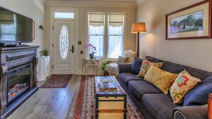 Una sala de estar con chimenea, sofá y televisión.