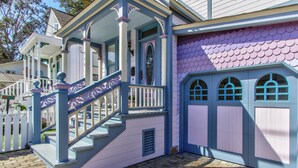 Una casa con porche, escaleras y un ventanal con marco decorativo.