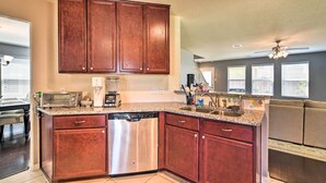 A modern kitchen with wooden cabinets, stainless steel appliances, and a granite countertop. - Spacious Conroe Home - 6 Mi to The Woodlands! (Conroe)
