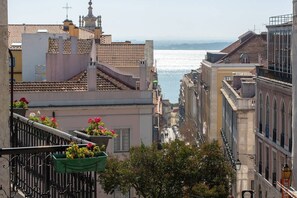 Vista de una calle urbana con edificios y una masa de agua al fondo.