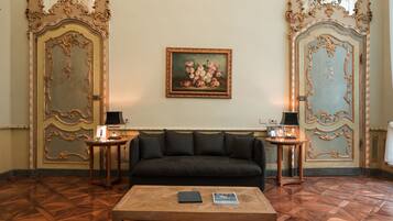 A room with a black sofa, a wooden coffee table, and two side tables with lamps.