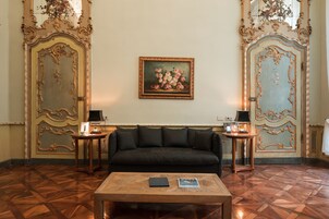 A room with a black sofa, a wooden coffee table, and two side tables with lamps.