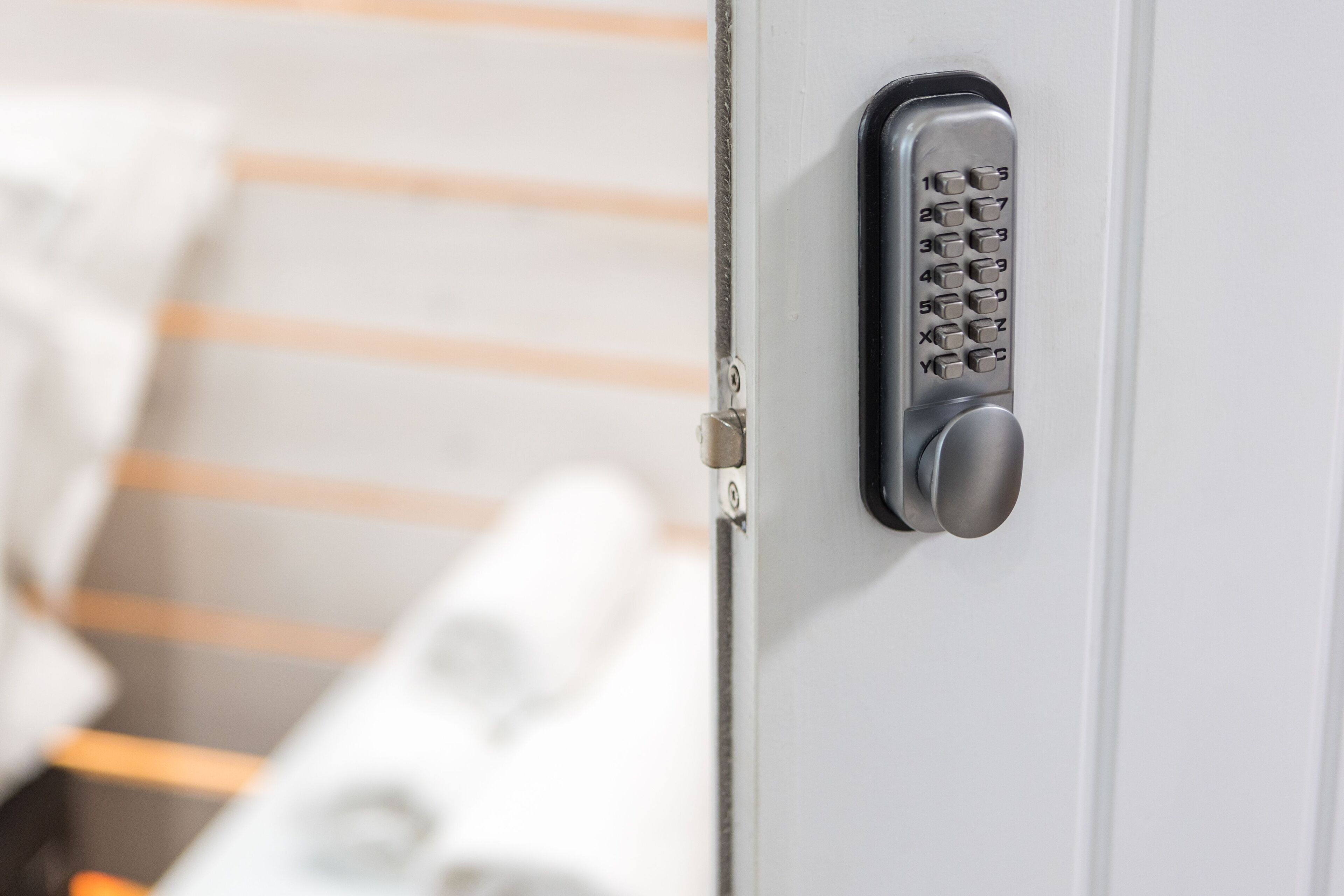 A close-up of a keypad lock on a door, likely for a hotel room.
