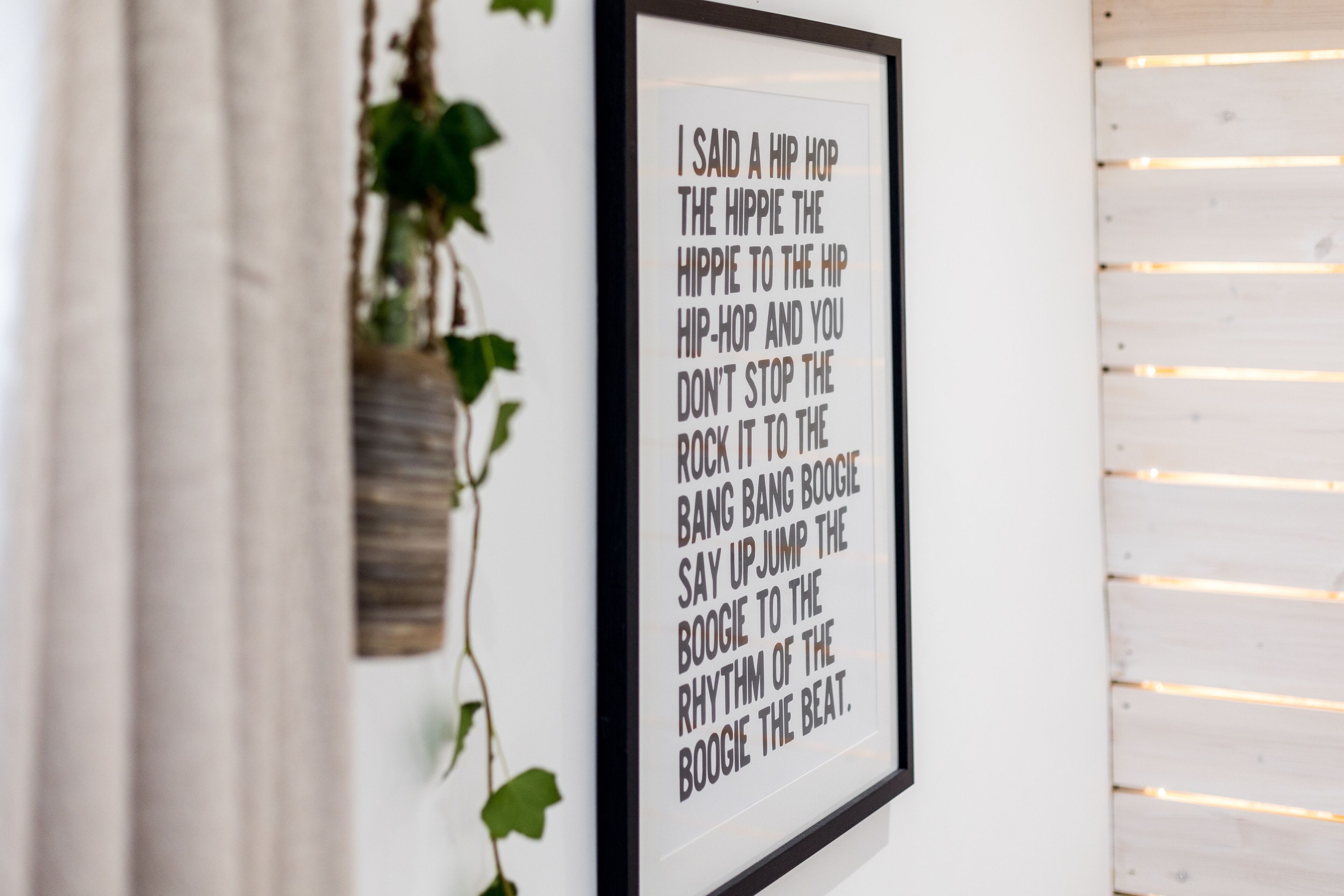 A framed quote on a wall with a wooden slat design.