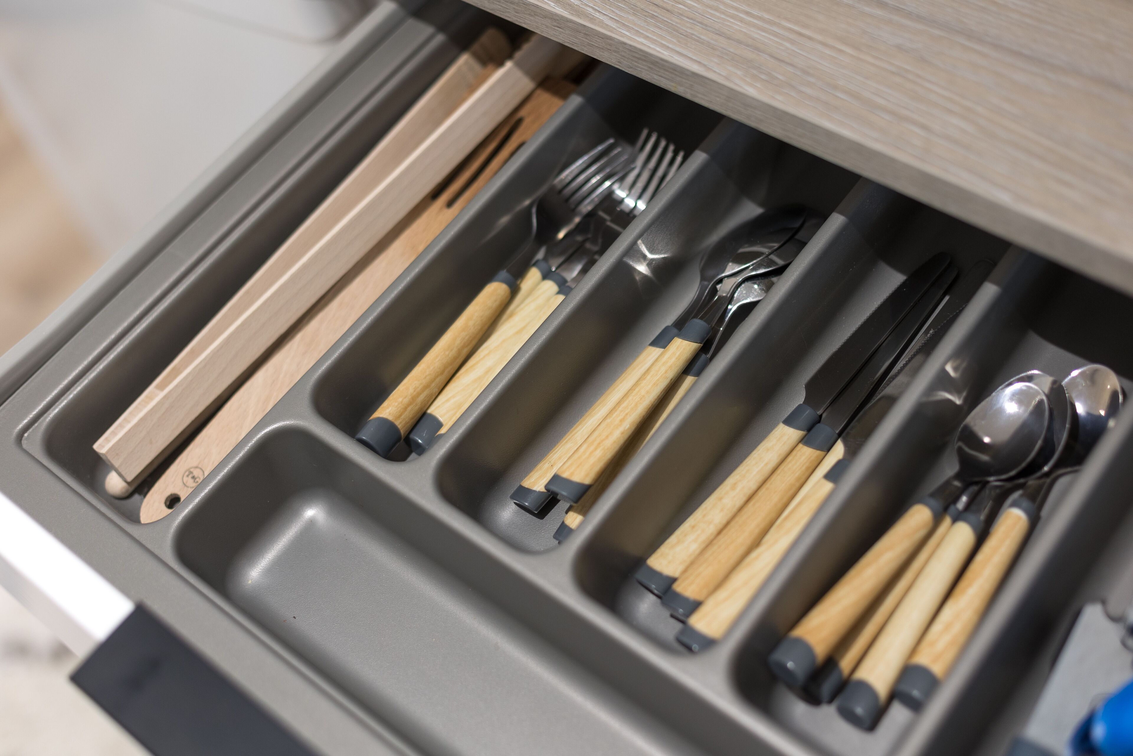 A drawer with utensils including forks, knives, and spoons.