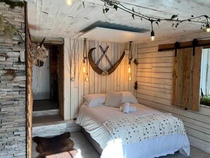 A cozy bedroom with a bed, wooden walls, and string lights. - James Place @ Pontmorlais (Merthyr Tydfil)