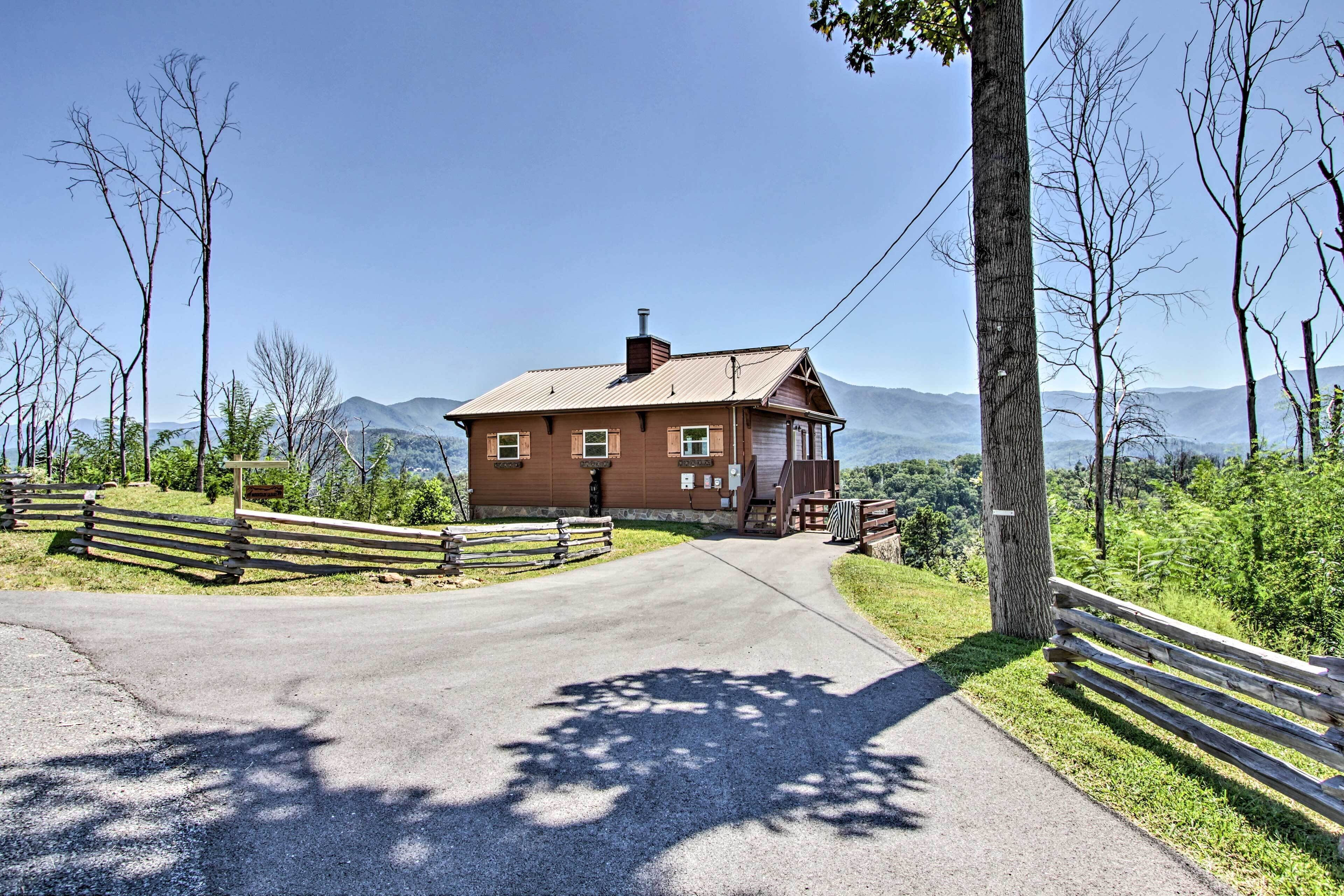 A rustic cabin with a sloped roof, a chimney, and a porch with a bench.
