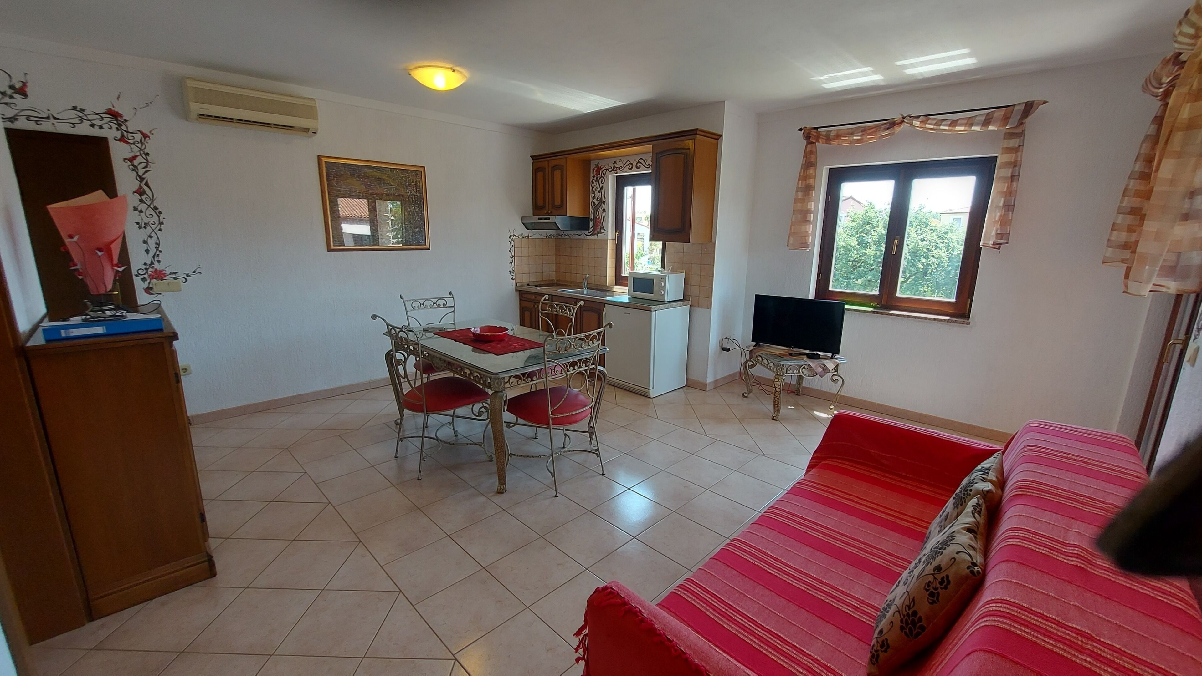 A compact living space with a dining area, kitchenette, and a sofa.