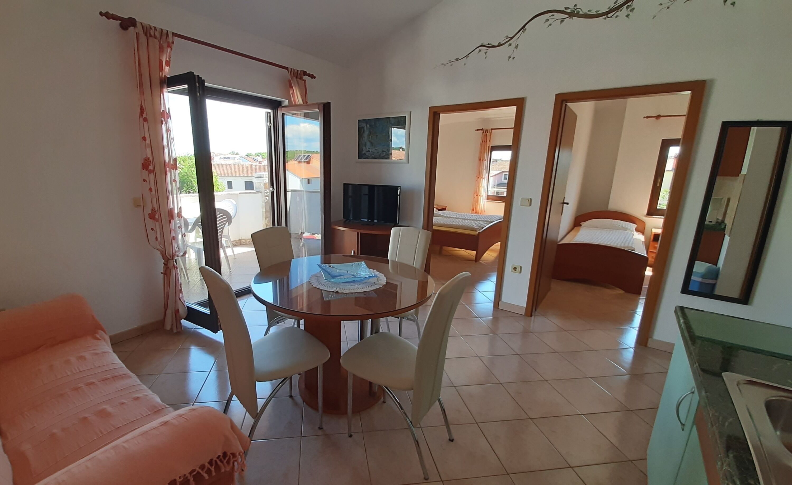 Una habitación con una mesa de comedor, sillas, un sofá, un televisor, una cama y un baño.