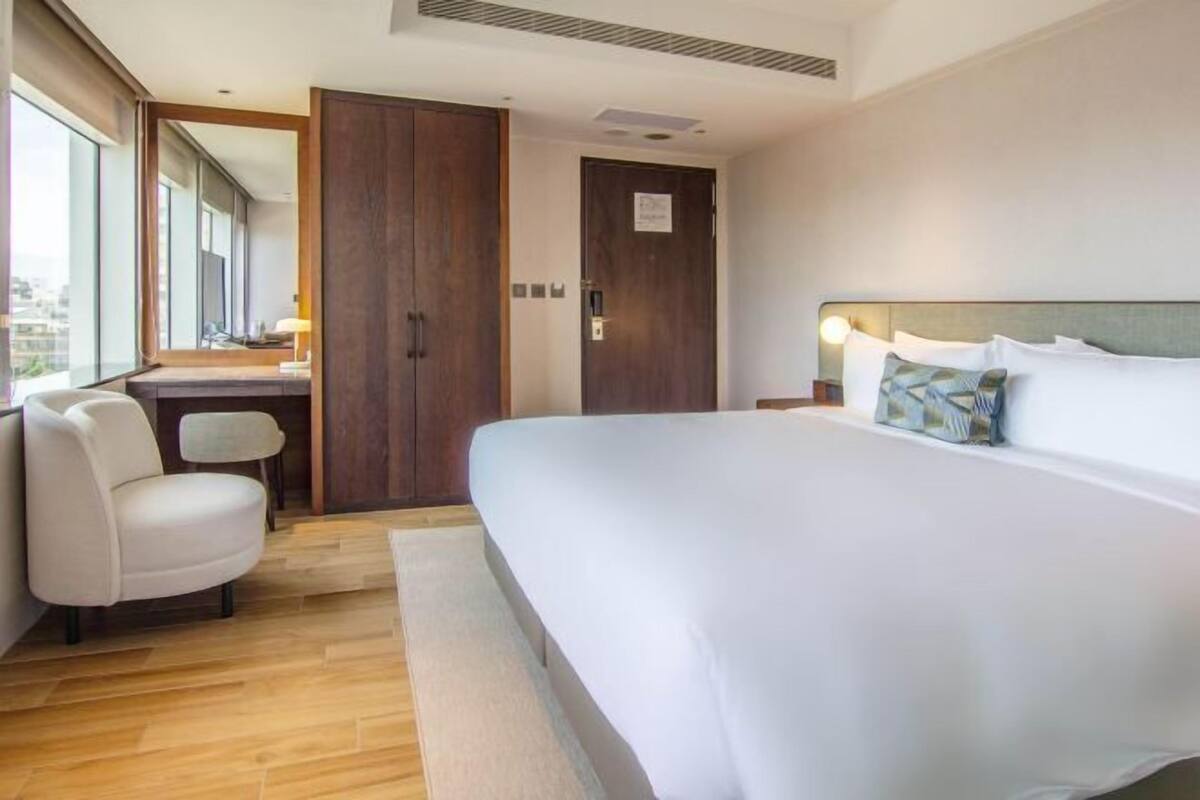 Een hotelkamer met een groot bed, een bureau, een stoel en een kledingkast.