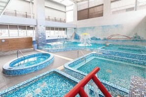 An indoor swimming pool with multiple lanes and a central water slide. - Kilin Hotel JiaoXi (Jiaoxi)