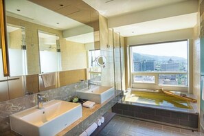 A modern bathroom with two sinks, a large mirror, and a bathtub with a view of the city. - Kilin Hotel JiaoXi (Jiaoxi)