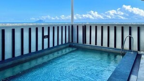 Una piscina sul tetto con vista chiara sullo skyline cittadino e sulle nuvole.