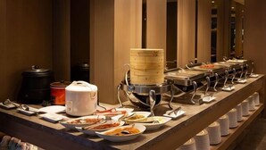 Un'area buffet con diversi cibi e un cuocitore a vapore.