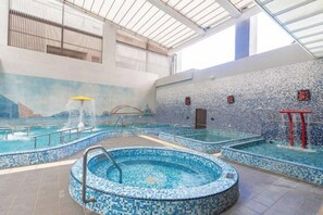 An indoor swimming pool with multiple lanes, a hot tub, and a mural on the wall. - Kilin Hotel JiaoXi (Jiaoxi)