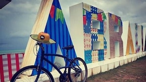 A bicycle parked next to a colorful wall with various patterns and designs.