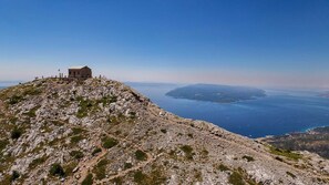 A rocky hilltop with a small building, offering a panoramic view of a coastline and distant islands. - Villa Donari - Early check in & late check out (Tugare)