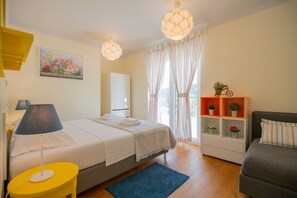 A bedroom with a bed, bedside lamps, a bedside table, a dresser, a chair, a window with curtains, and a shelf with plants. - Villa Donari - Early check in & late check out (Tugare)