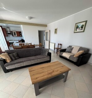 Un salon comprenant un canapé, une table basse et un coin repas avec une table et des chaises.