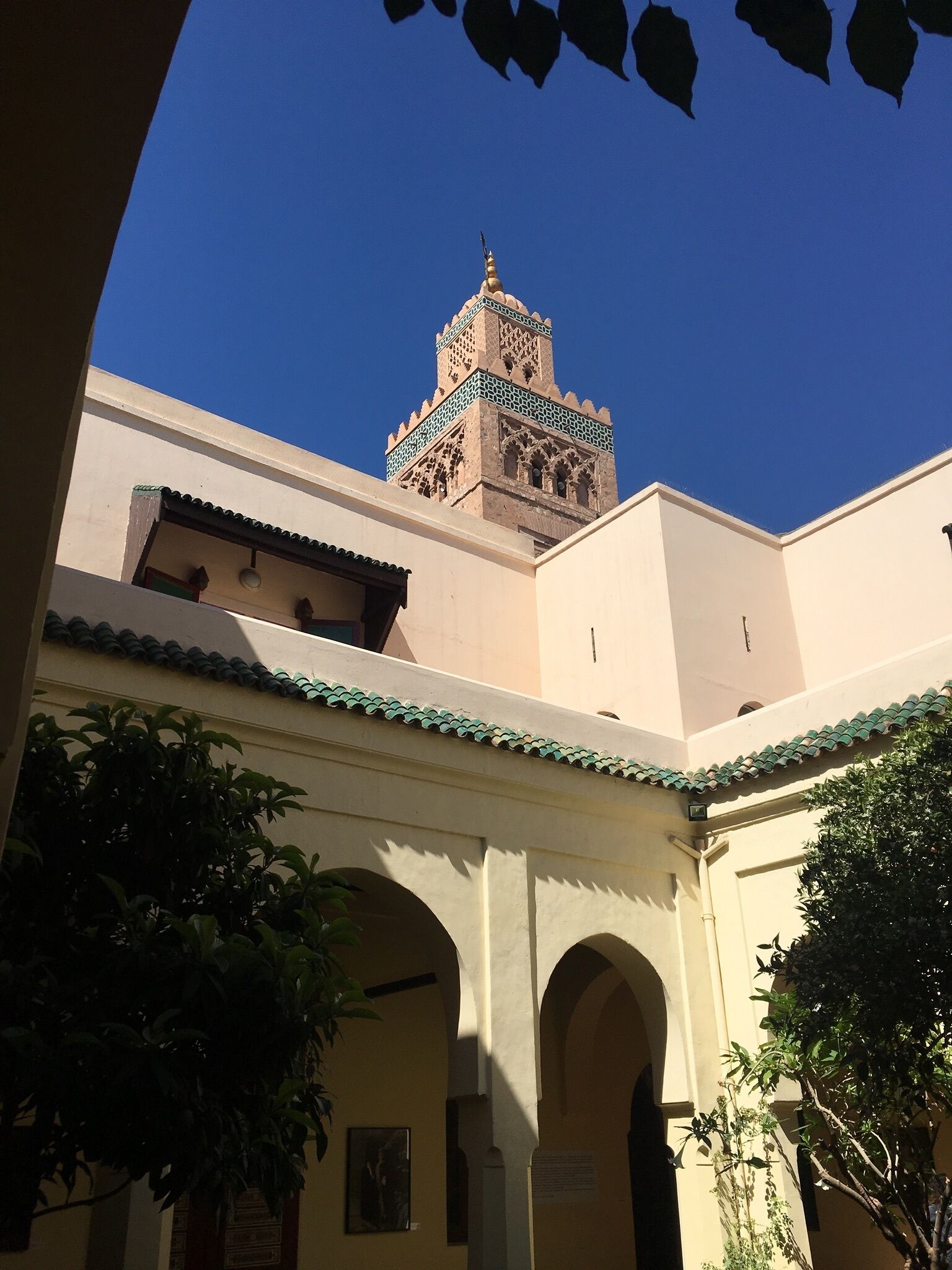Ein Innenhof mit einem Gebäude, das einen Turm mit aufwendigen Verzierungen und eine Kuppel zeigt.