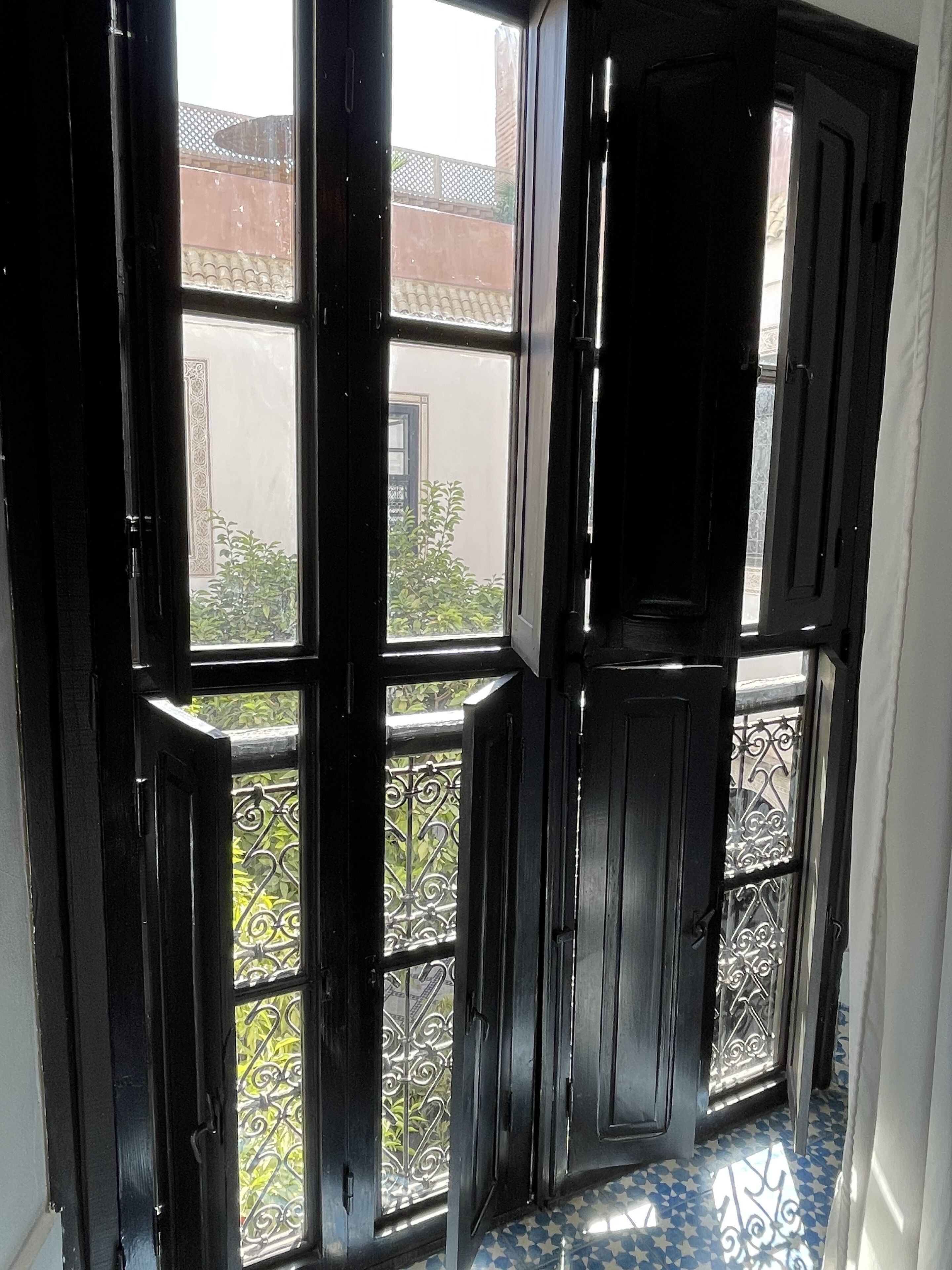 Uma porta preta com vários painéis de vidro e guarda-corpo de metal na varanda.