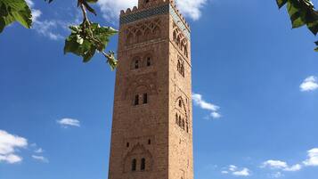 A tall, historic tower with intricate architectural details and a clear blue sky in the background.