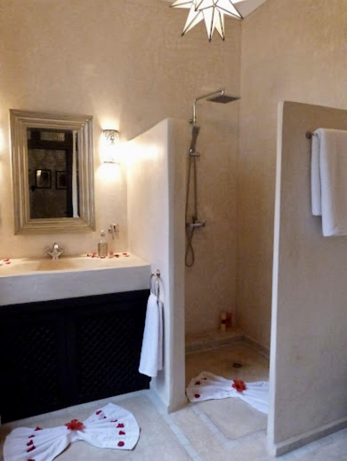 A bathroom with a sink, mirror, and shower.