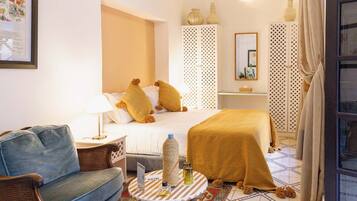 A hotel room with a bed, a chair, a small table with a menu, and decorative items.