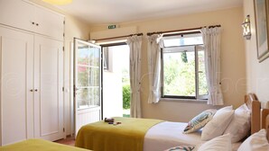 A room with two beds, a wardrobe, and a window with curtains. - GARDEN APARTMENT   (Lagos)