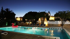 A swimming pool with lounge chairs and a stone wall. - GARDEN APARTMENT   (Lagos)