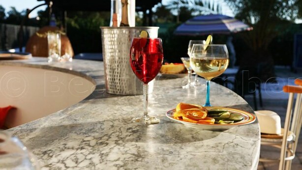 A marble bar with two glasses of wine, a cocktail, and a plate of fruit. - GARDEN APARTMENT   (Lagos)