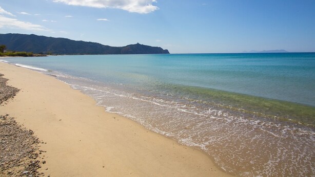 A beach with clear water, a sandy shore, and distant mountains. - semidetached beach villa in front of eolian island near Milazzo: Tindari (furnari)